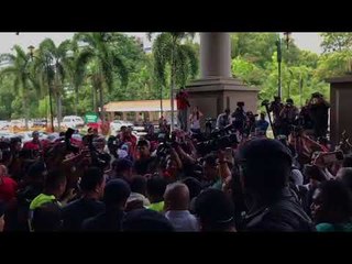 Police personnel escort a protester out of KL Courts Complex