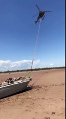 un hélicoptére tracte un bateau