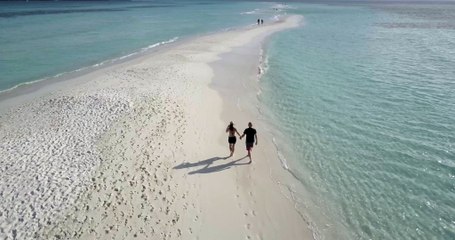 Couple Walking on a Beach Filmed with a Drone
