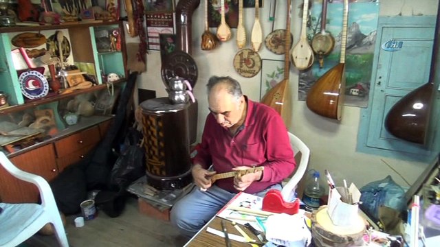 Üç telli bağlamayı hem yapıyor hem çalıyor