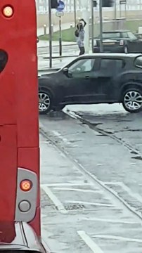 Dans la rue ce type danse contre un panneau de signalisation !