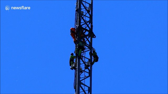 Scared of heights? This video of workers atop soaring tower may make you queasy