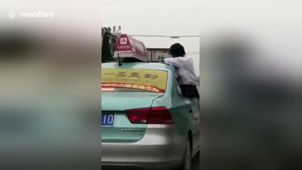 Schoolgirl hangs out of window to finish homework on roof of taxi