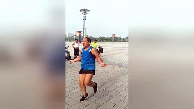 Man performs skipping rope moves in city square