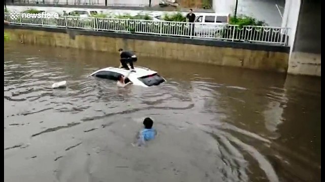 Woman rescued from car trapped in flooded street