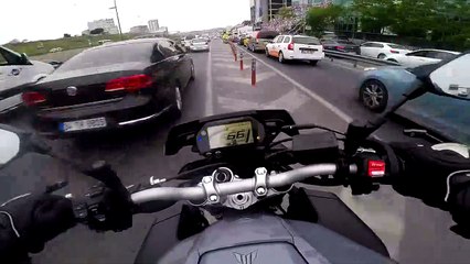 Un motard remonte une file de voitures comme un fou.