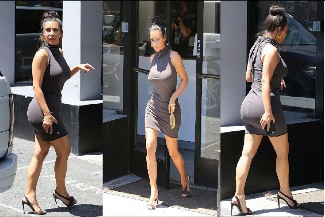 Kim Kardashian squeezes her shapely rear into a turtleneck dress