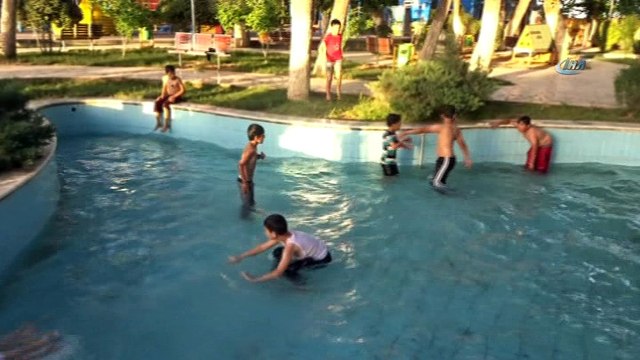 Sıcaktan bunalan çocuklar süs havuzlarında serinliyor