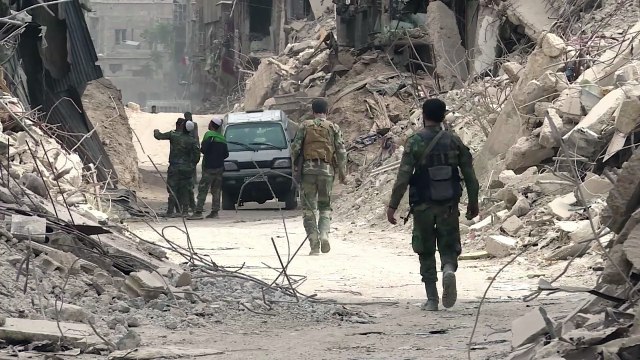 في مخيم اليرموك في دمشق دمار يطغى على الشوارع وجنود يحتفلون بالنصر