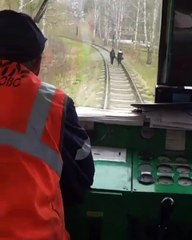 Un train fait peur à des filles sur une voie ferrée