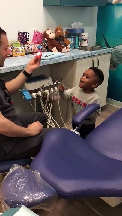 Un dentiste fait de la magie à un enfant