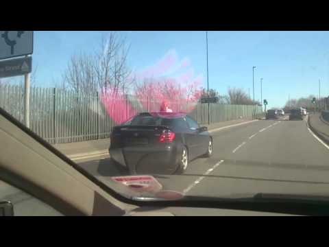 Car drives along with a child sticking out of sun roof