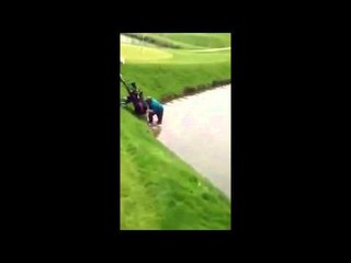 Golfer rescues a golf trolley from lake & even goes back in for the putter.