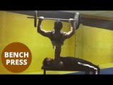 Fitness fanatic lifts friend in a bench press of over 120kg.