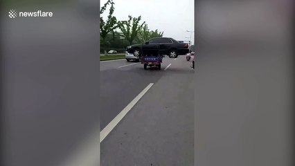 Three-wheeler transports entire sedan on busy main road