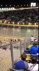 Un spectateur prend de la hauteur sur un grillage durant une course