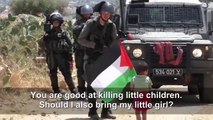 Palestinian parent push his son toward Israeli soldiers
