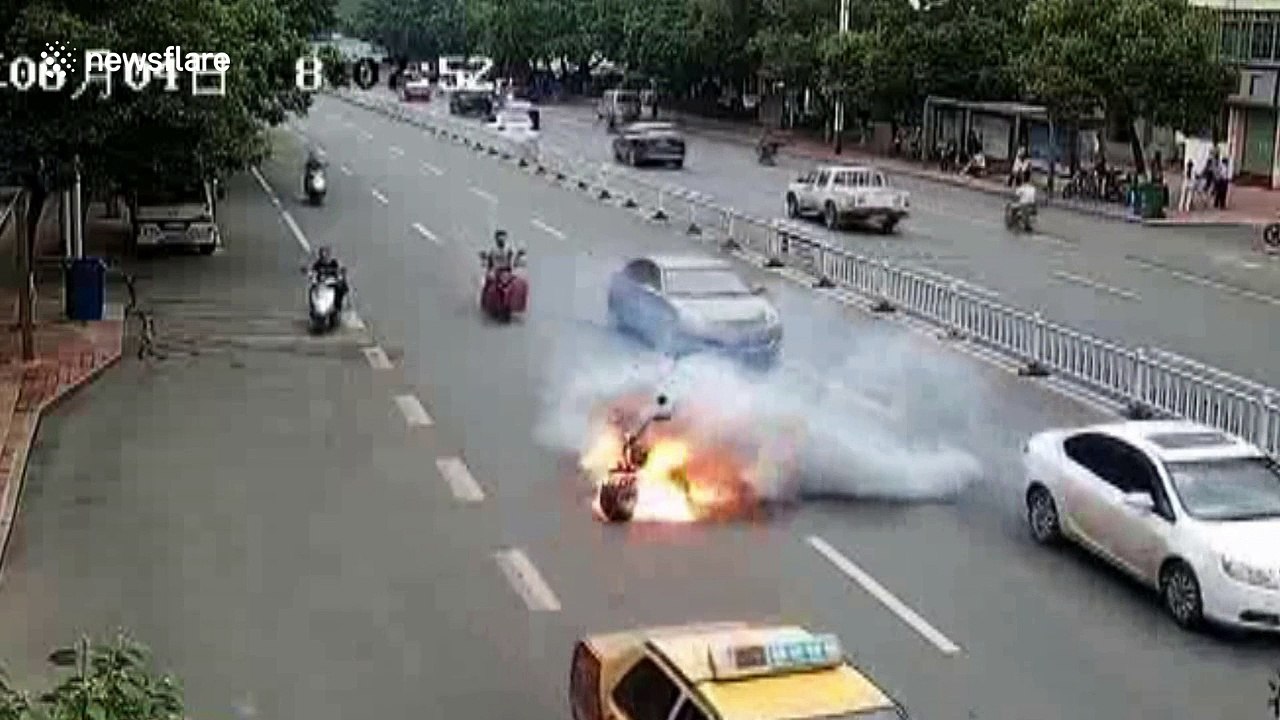 Two men leap off moving scooter after it bursts into flames on busy road