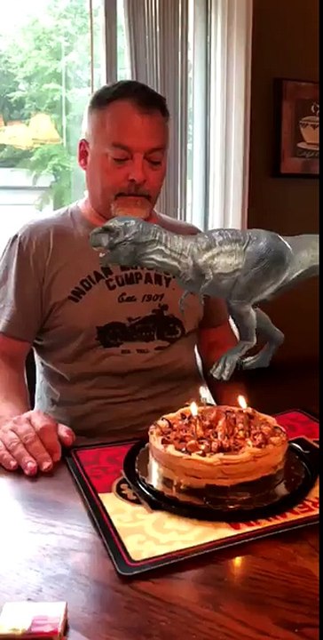 Elle utilise le filtre Dinosaure pendant que son père souffle les bougies