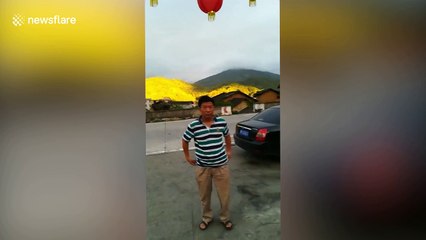 Chinese tourists pose in front of 'golden mountain'