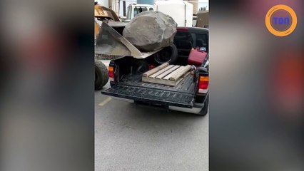 Il charge un rocher dans un pick-up