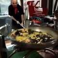 Chef handling an enormous frying pan   