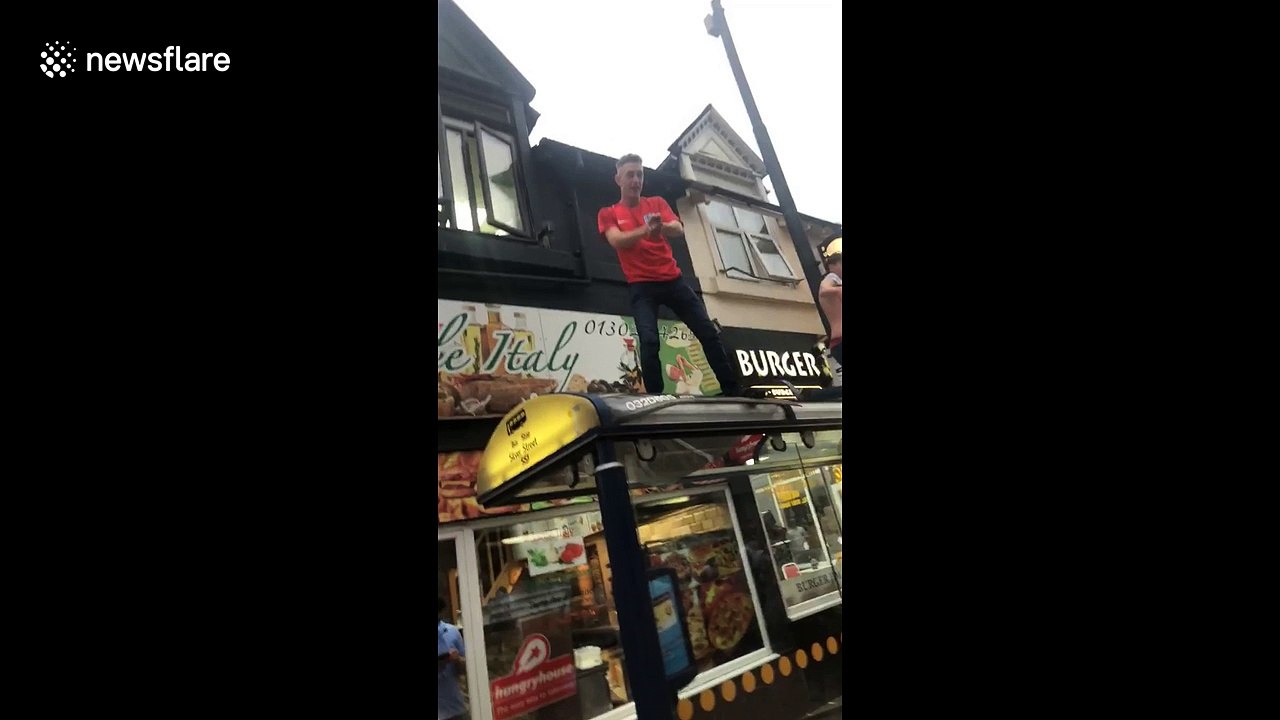 Man leaps from bus shelter into crowd celebrating England win