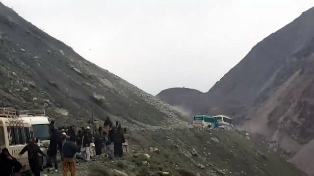Un bus bloqué sous une pluie de rochers sur une route de montagne