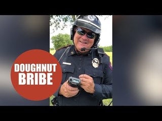 Hilarious footage shows a policeman being bribed with a doughnut.