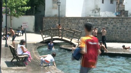 Diyarbakır’da aşırı sıcaklardan bunalan çocuklar süs havuzuna girerek serinledi