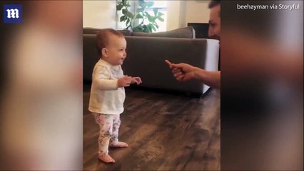 شاهد.. أب يشجع طفلته على أن تخطو أولى خطواتها بهذه الحيلة الطريفة