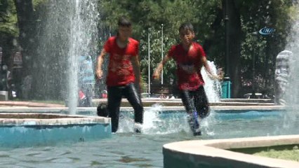 Hava sıcaklığından bunalan çocuklar süs havuzunda serinliyor