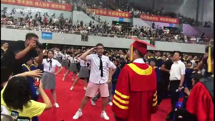 Students perform dance in front of university president at graduation