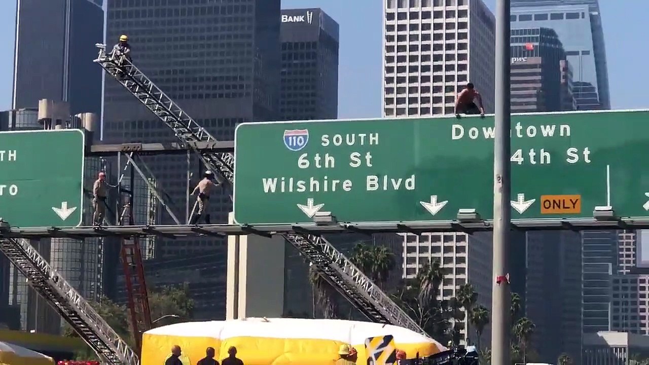 LOS ANGELES : Un homme fou saute du haut d'un panneau de signalisation routière