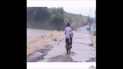 Un motard traverse une route inondée : mauvaise idée