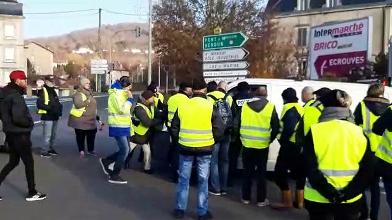 Un policier sort son arme pour protéger des gilets jaunes d'un automobiliste excédé qui force un barrage
