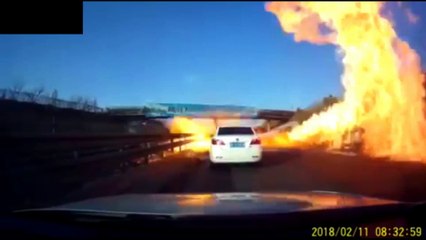 Une voiture roule sur un déversement d'essence et la route explose