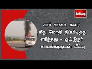 கார் சாலை சுவர் மீது மோதி தீப்பிடித்து எரிந்தது - ஓட்டுநர் காயங்களுடன் மீட்பு