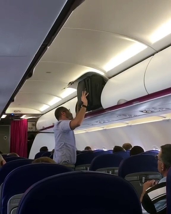 Il essaye de faire rentrer sa valise dans le compartiment
