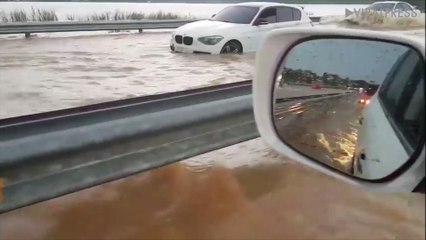 Cars Drive Through Flooded Road