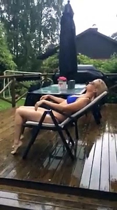 Une suédoise en bikini sous la pluie tente de bronzer