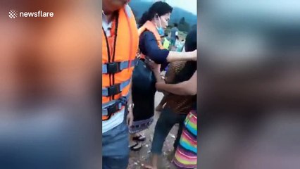 Heartbreaking moment woman holds baby after losing home in Laos flooding