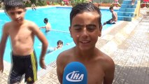 Sıcaktan bunalan Türk ve Suriyeli  gençler havuzda yüzerek serinliyor