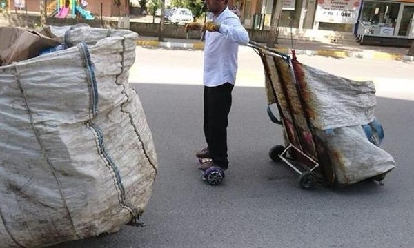 Kağıtları elektrikli kaykay ile topluyor