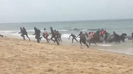 شاهد لحظة وصول مهاجرين أفارقة  إلى شاطئ سياحي في إسبانيا وسط دهشة المصطافين