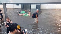 Commuters wade and float through flooded Swedish station