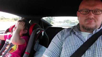 Une petite fille adore les voitures de course