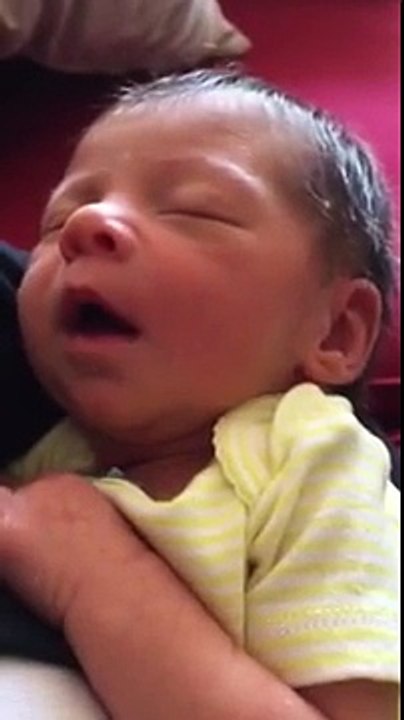 Sleeping newborn making funny faces.