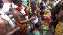 Priest breaks coconuts on devotees' heads during Indian festival
