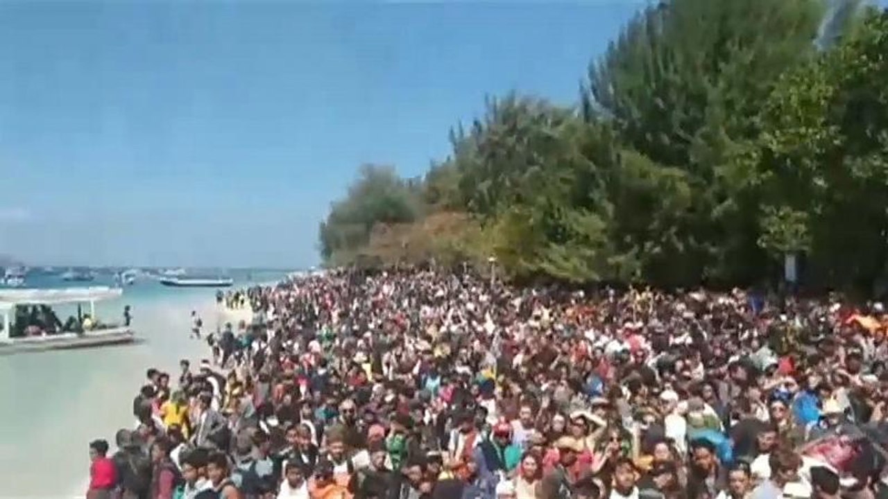Menschen warten am Strand auf ihre Rettung